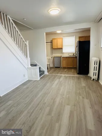 a view of a kitchen with wooden floor and electronic appliances