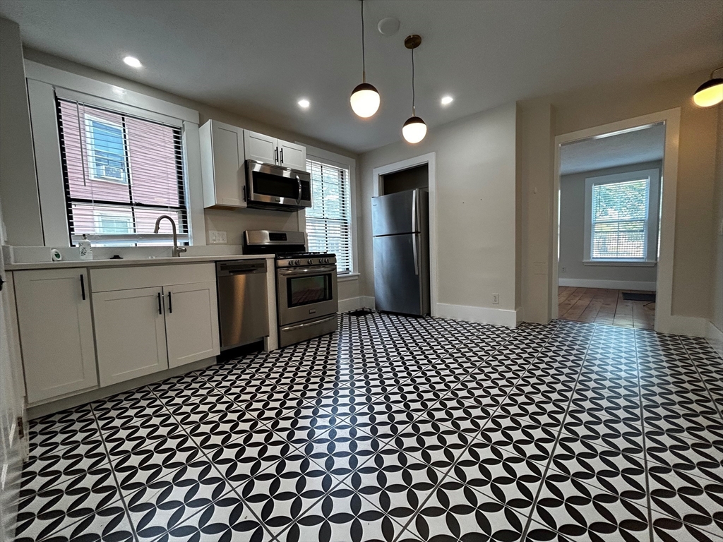 55 Hale Street, Unit 1 Beverly, MA 01915 - Photo 5 of 13 a kitchen with a sink a window and stainless steel appliances