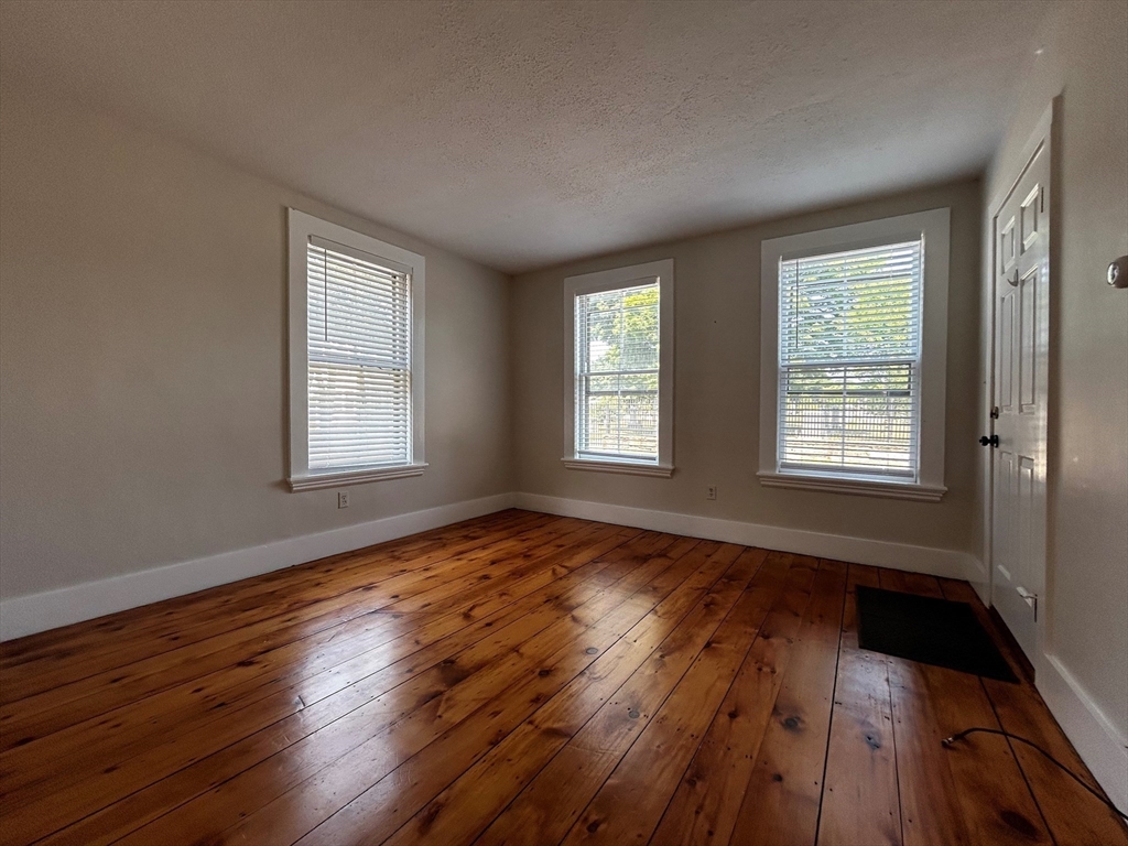 55 Hale Street, Unit 1 Beverly, MA 01915 - Photo 7 of 13 a view of an empty room with wooden floor and a window