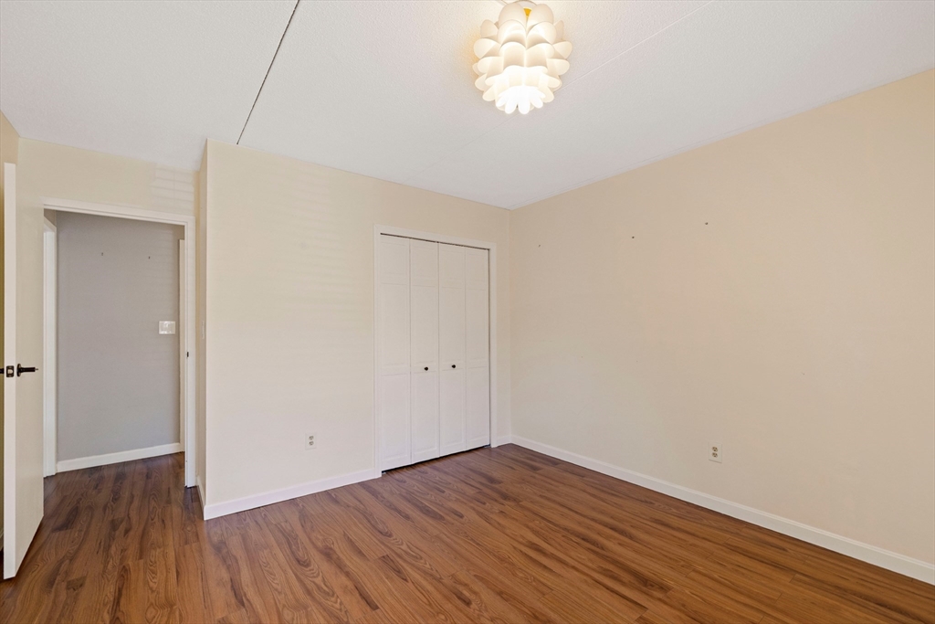 50-56 Broadlawn Park, Unit 221 Boston, MA 02467 - Photo 12 of 29 a view of a room with wooden floor and a chandelier fan