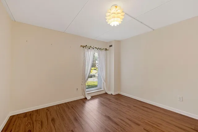 an empty room with wooden floor and a window