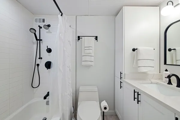a bathroom with a sink a toilet and shower
