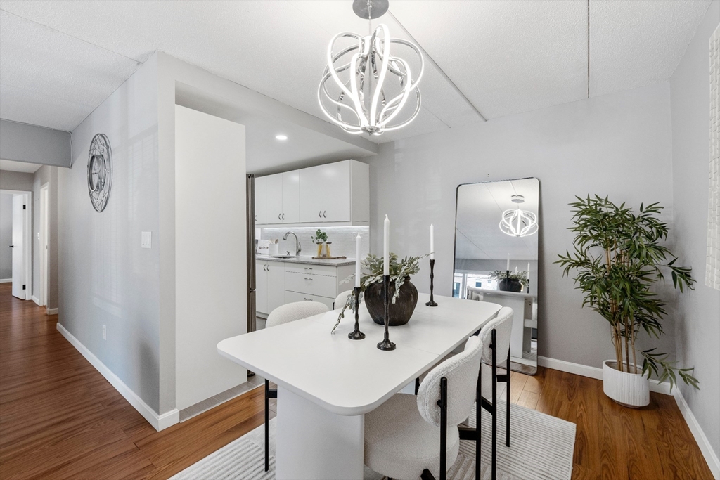 50-56 Broadlawn Park, Unit 221 Boston, MA 02467 - Photo 5 of 29 a view of a dining room with furniture wooden floor and chandelier