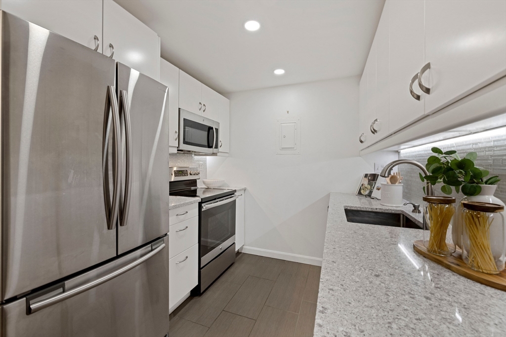 50-56 Broadlawn Park, Unit 221 Boston, MA 02467 - Photo 7 of 29 a kitchen with stainless steel appliances a refrigerator and a sink