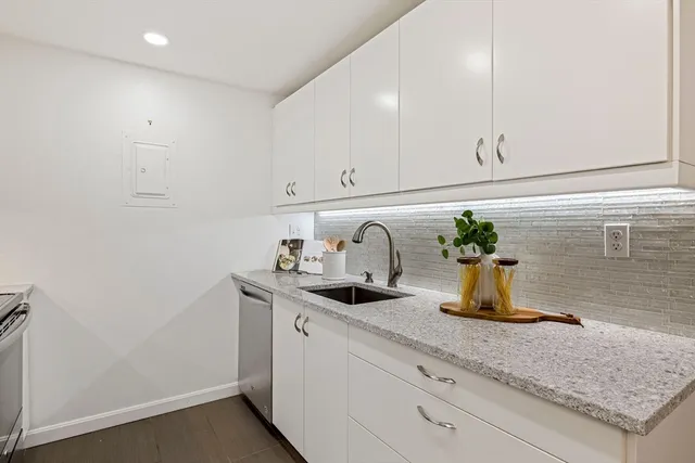a kitchen with sink and white cabinets
