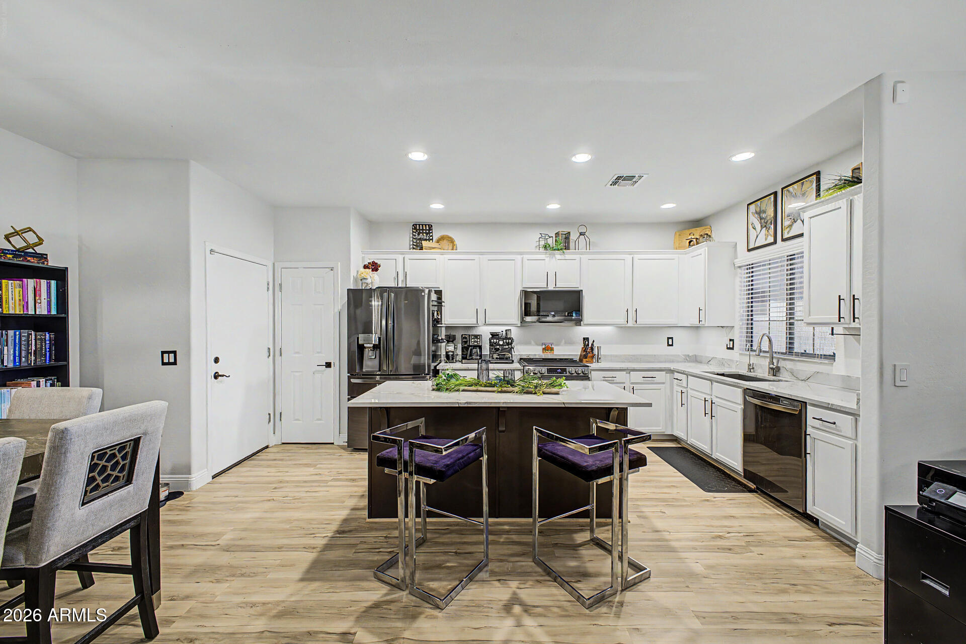4924 West Harwell Road Laveen, AZ 85339 - Photo 10 of 27 a kitchen with stainless steel appliances kitchen island granite countertop a table chairs sink and cabinets