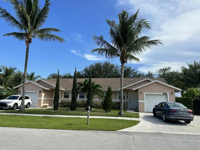 a car parked in front of a house with a yard