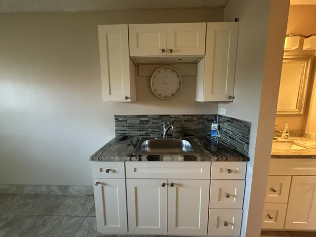 a kitchen with white cabinets and a sink