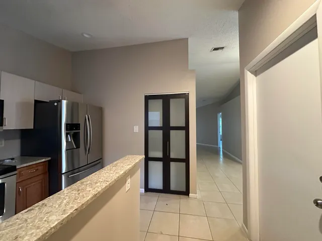 a kitchen with stainless steel appliances granite countertop a refrigerator and a sink