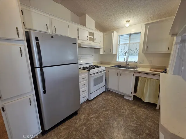 a kitchen with stainless steel appliances a refrigerator sink and cabinets