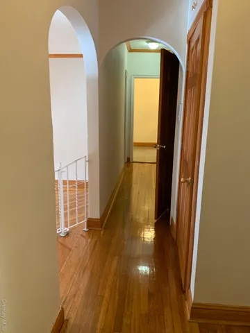 a view of a hallway with wooden floor and staircase