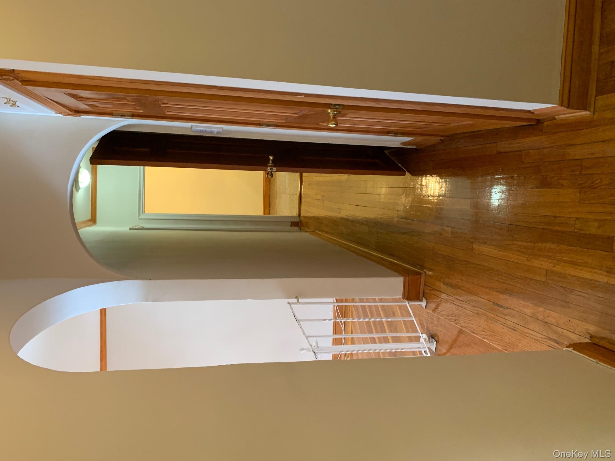 43-33 48th Street, Unit 3C Queens, NY 11104 - Photo 13 of 15 a view of a hallway with wooden floor and staircase