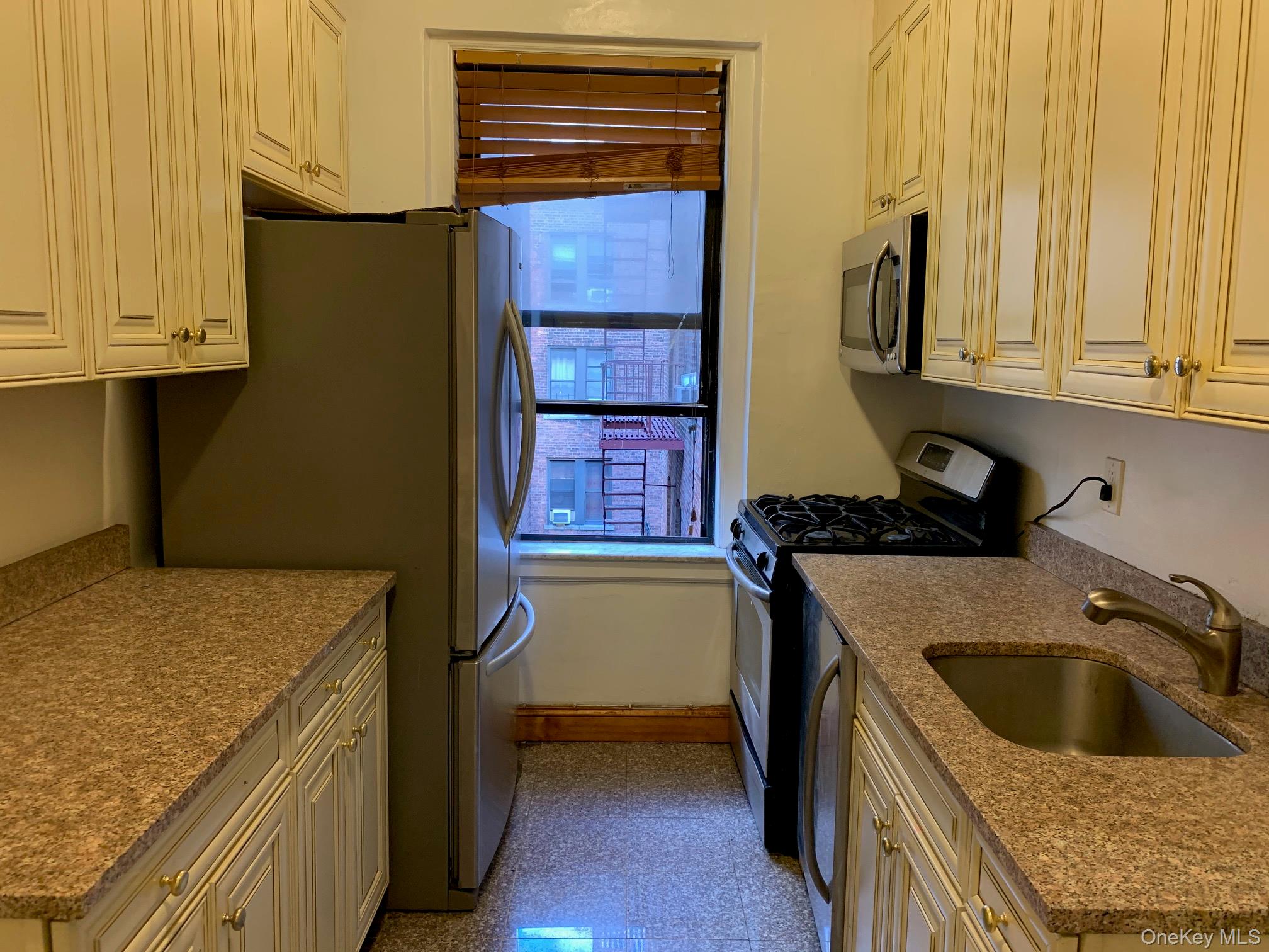 43-33 48th Street, Unit 3C Queens, NY 11104 - Photo 7 of 15 a kitchen that has a sink and a stove