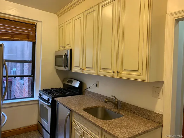 a kitchen with stainless steel appliances granite countertop a sink stove and cabinets