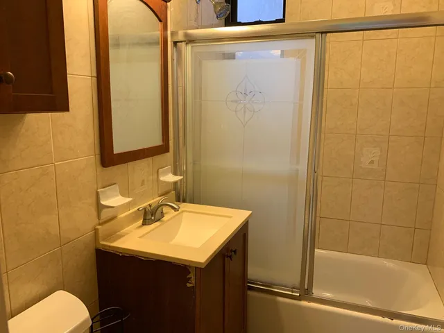 a bathroom with a sink and mirror with bathtub