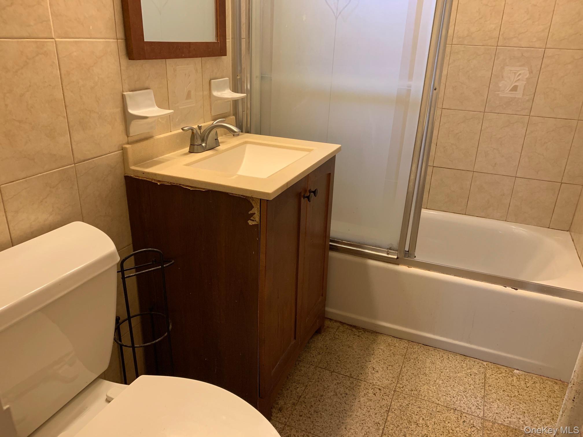 43-33 48th Street, Unit 3C Queens, NY 11104 - Photo 10 of 15 a bathroom with a sink a toilet and shower