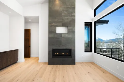 a living room with a fireplace and a floor to ceiling window