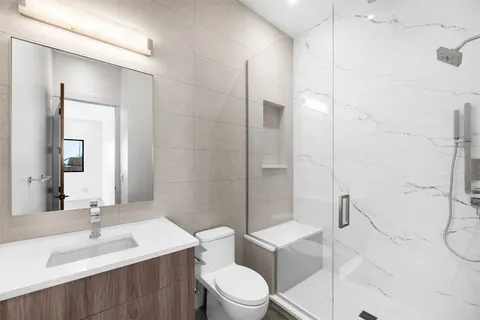 a bathroom with a sink a toilet and shower