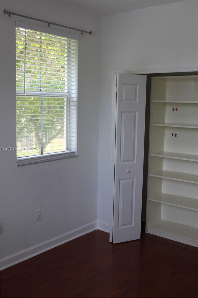 11675 Northwest 78th Lane Doral, FL 33178 - Photo 10 of 12 a view of empty room with wooden floor and fan