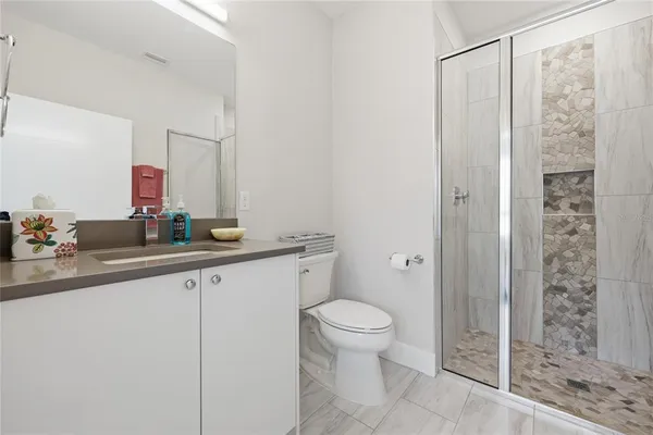 a bathroom with a sink vanity mirror and toilet