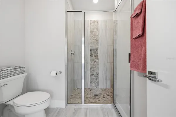 a bathroom with a shower sink vanity and mirror