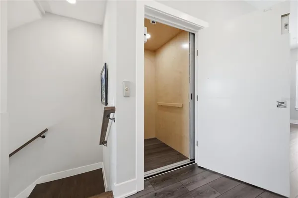 a view of a hallway with wooden door and staircase