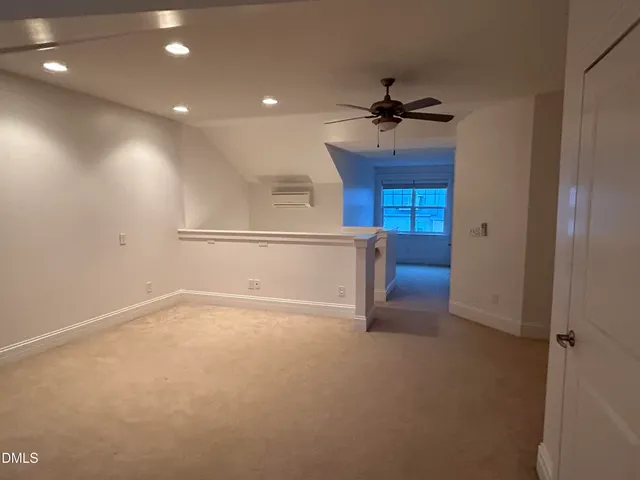 an empty room with closet and a ceiling fan