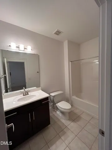a bathroom with a tub sink shower and two mirror