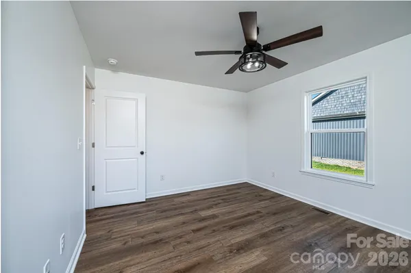 an empty room with a window and a ceiling fan