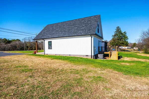 a front view of house with yard and trees in the background