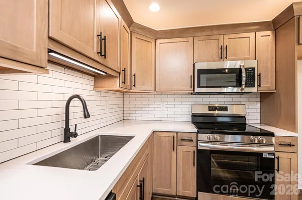 a kitchen with a stove a sink and a microwave