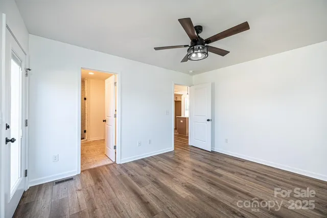 a view of room with wooden floor and ceiling fan