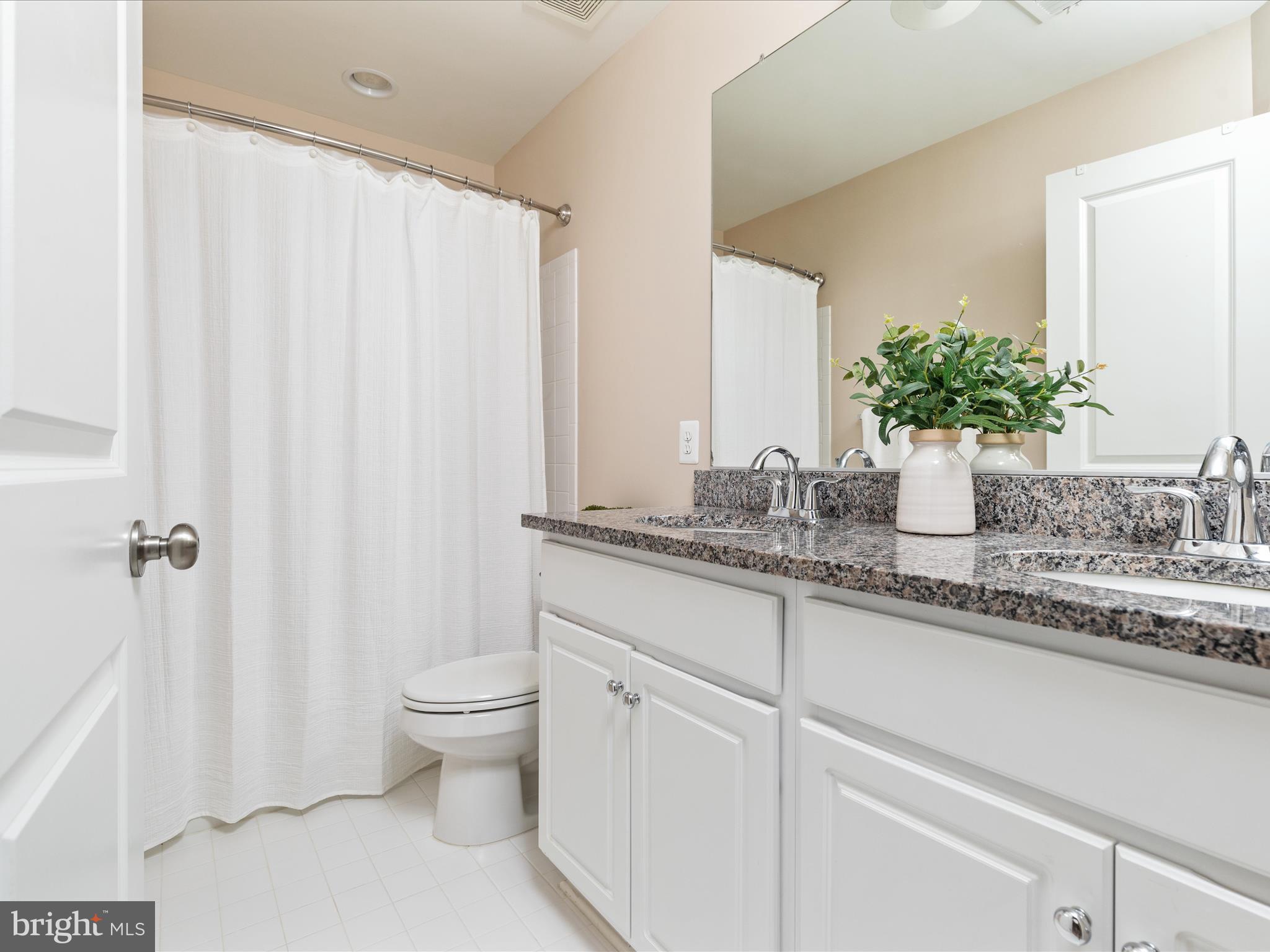 14353 Northbrook Lane Gainesville, VA 20155 - Photo 20 of 63 a bathroom with a granite countertop sink a toilet and a mirror