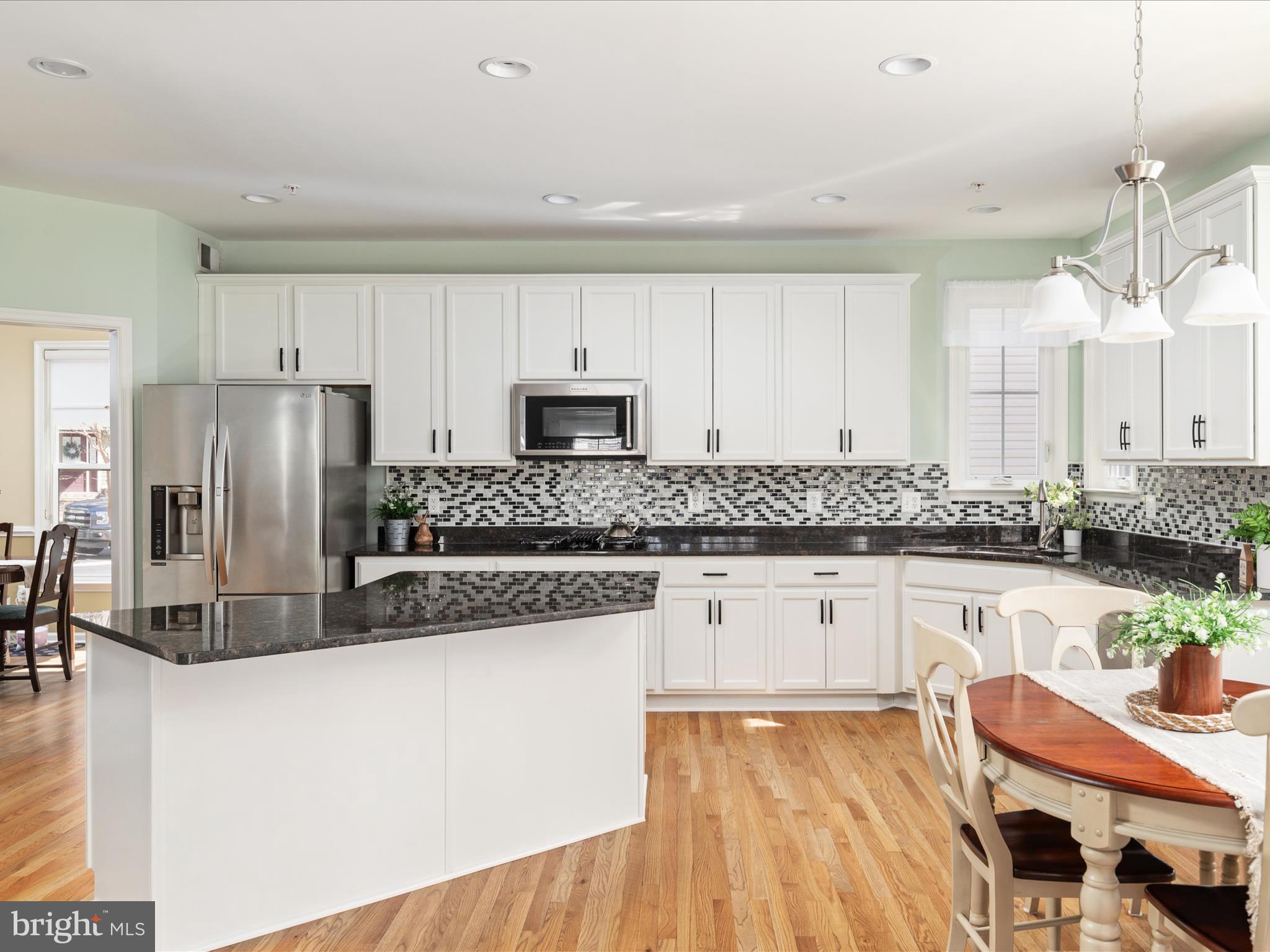14353 Northbrook Lane Gainesville, VA 20155 - Photo 8 of 63 a kitchen with stainless steel appliances granite countertop a refrigerator a stove a sink dishwasher and white cabinets with wooden floor