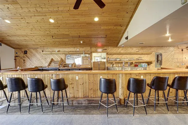 a dining room with lots of wooden furniture and a chandelier