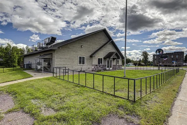 a view of a house with a big yard and sitting area