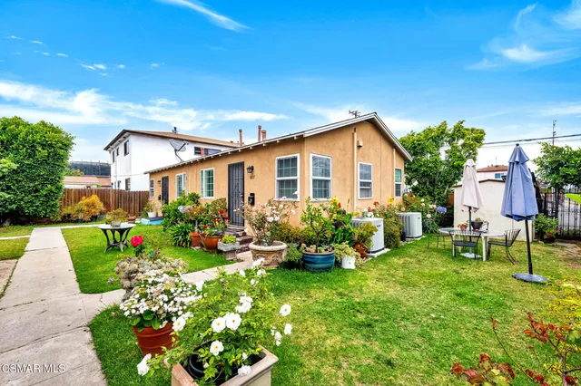 a view of a house with backyard and sitting area