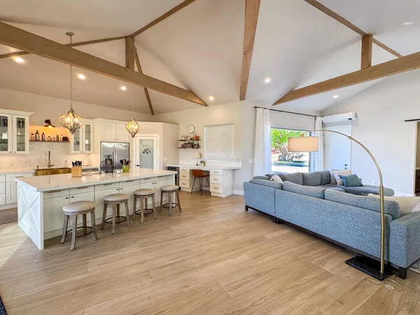 a living room with lots of furniture and kitchen view