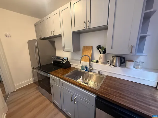 a kitchen with stainless steel appliances granite countertop a sink refrigerator and cabinets