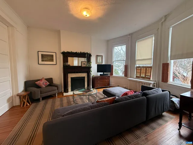 a living room with furniture fireplace and a large window