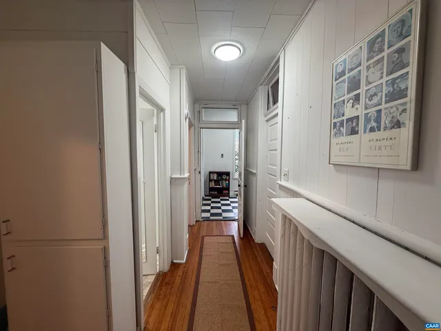 a view of a hallway with wooden floor and staircase