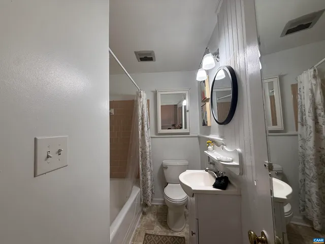 a bathroom with a toilet a sink and mirror