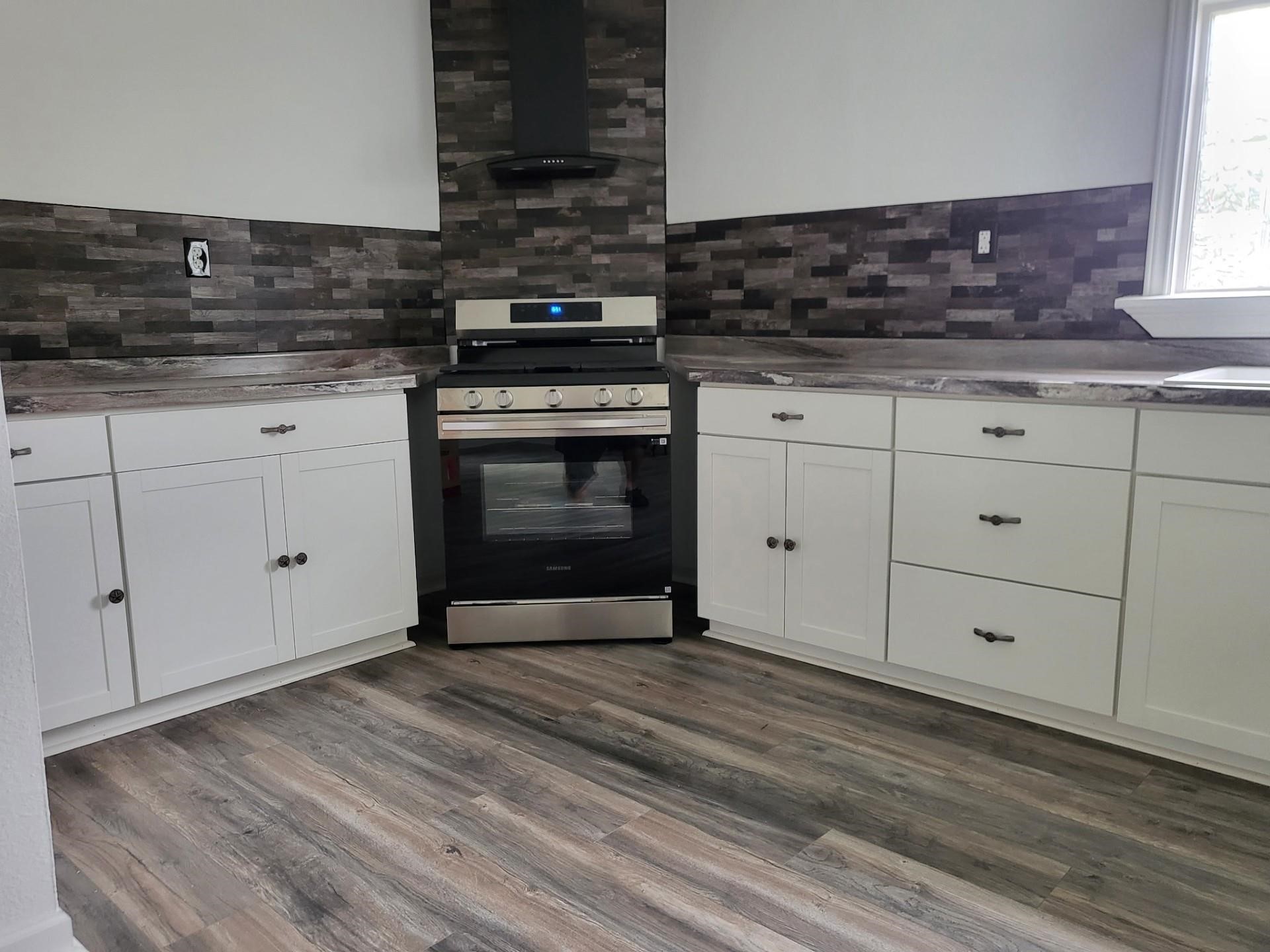 639 Manor Street Houston, TX 77015 - Photo 19 of 31 a kitchen with granite countertop a stove oven and white cabinets