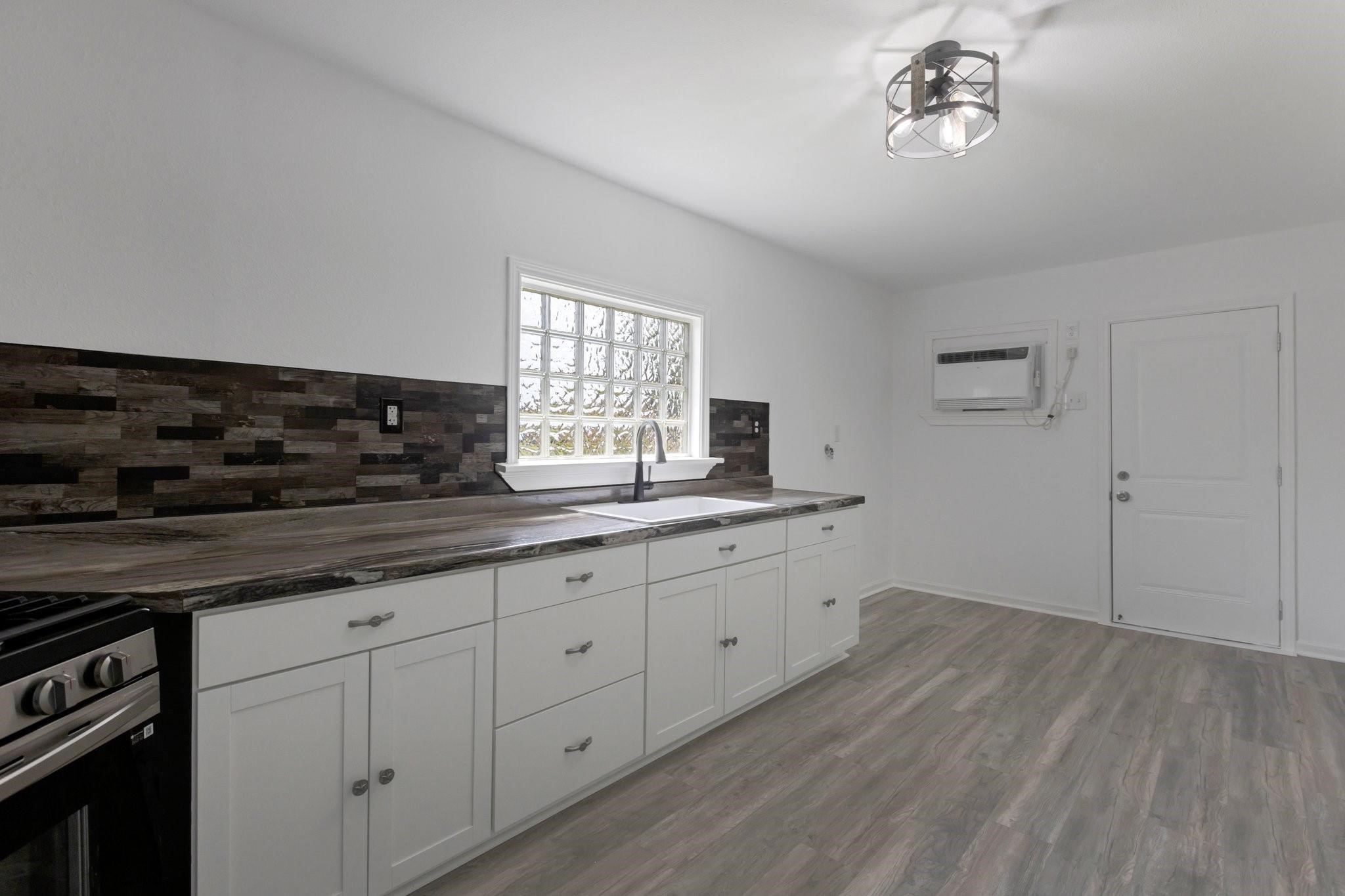 639 Manor Street Houston, TX 77015 - Photo 20 of 31 a kitchen with granite countertop white cabinets and window