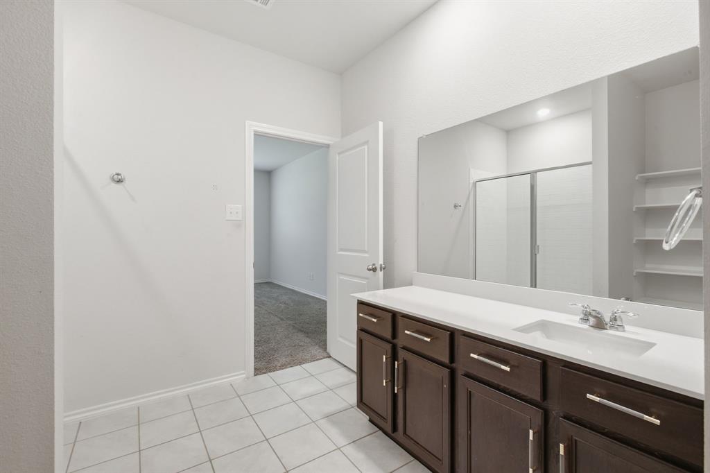1328 Broaddus Road Forney, TX 75126 - Photo 19 of 31 Bathroom featuring a spacious vanity with dark wood cabinetry, white countertop, and an integrated sink