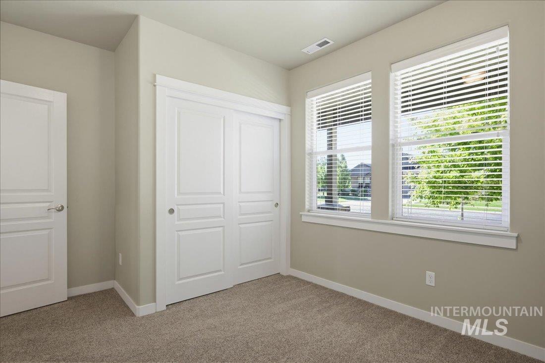 12460 West Azure Street Boise, ID 83713 - Photo 23 of 34 Room featuring two windows with white blinds, a white bi-fold closet, and a white interior door