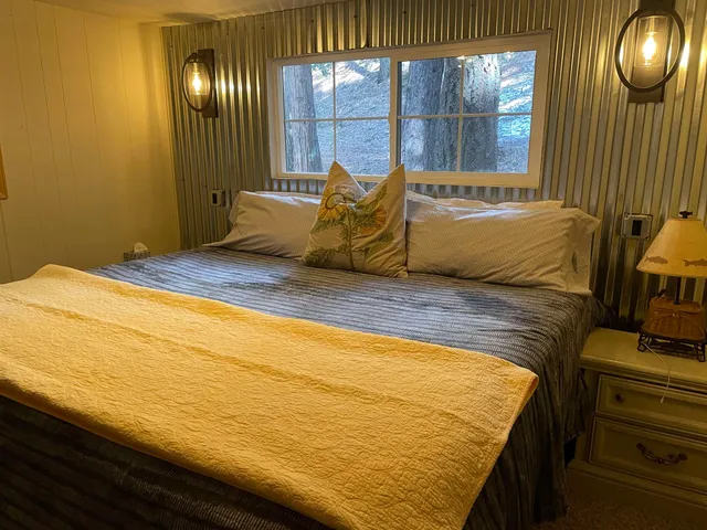 a bed sitting in a bedroom next to a window