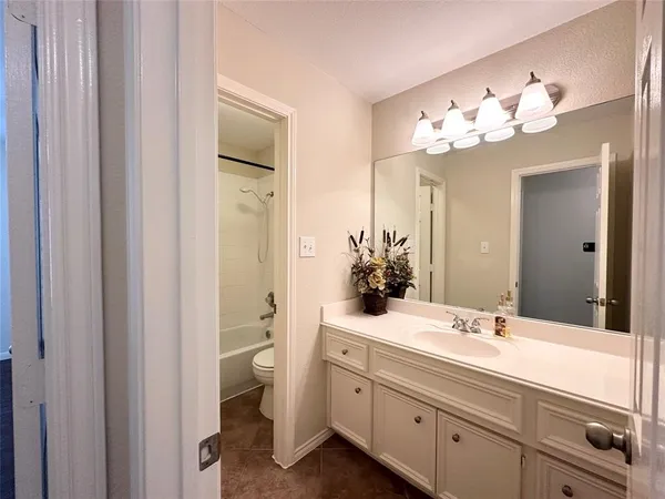 a white toilet and tub sitting next to a bathroom sink