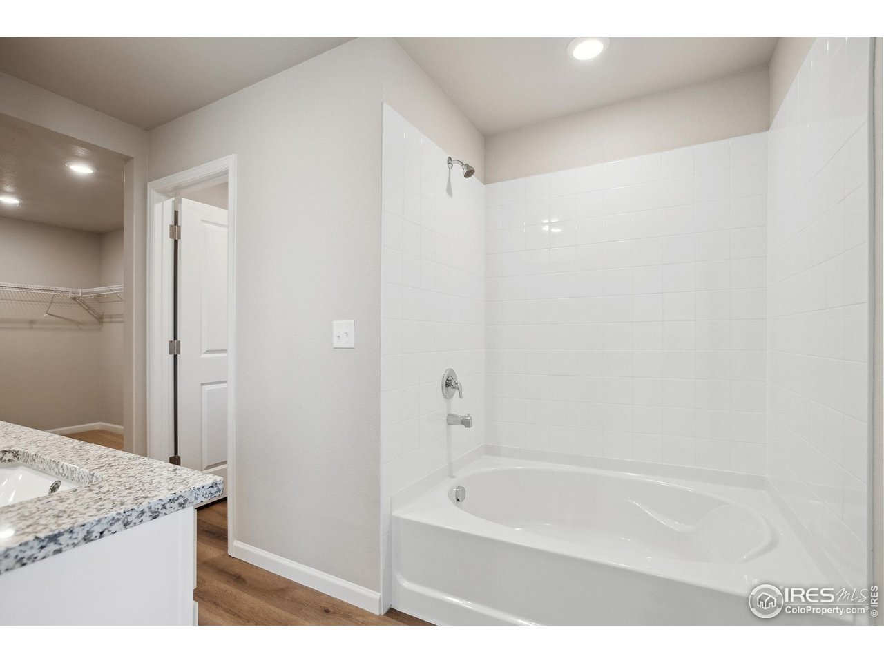 199 Robin Road Johnstown, CO 80534 - Photo 12 of 30 a bathroom with a granite countertop sink a mirror and a bathtub