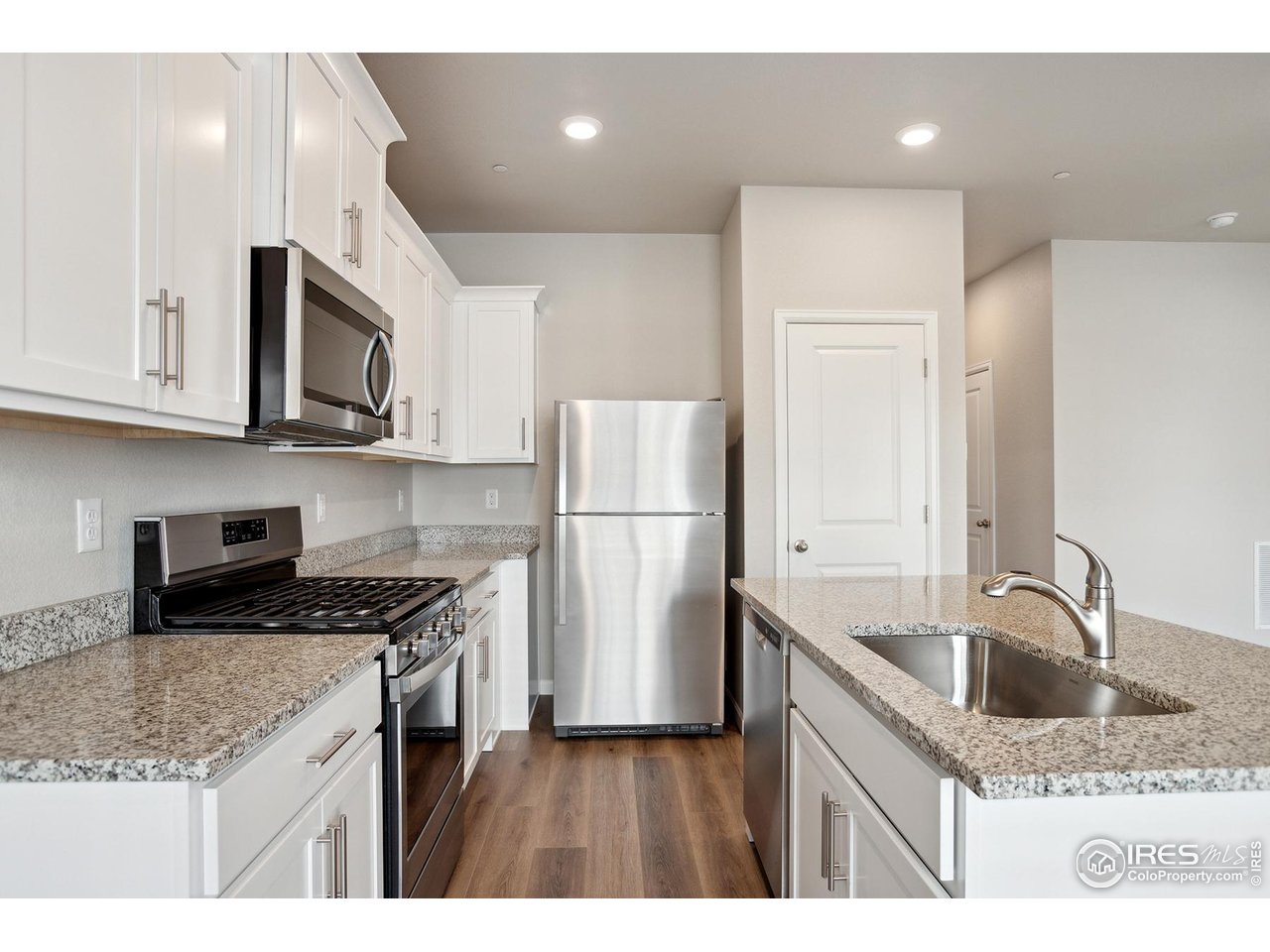 199 Robin Road Johnstown, CO 80534 - Photo 6 of 30 a kitchen with stainless steel appliances granite countertop a sink stove and refrigerator